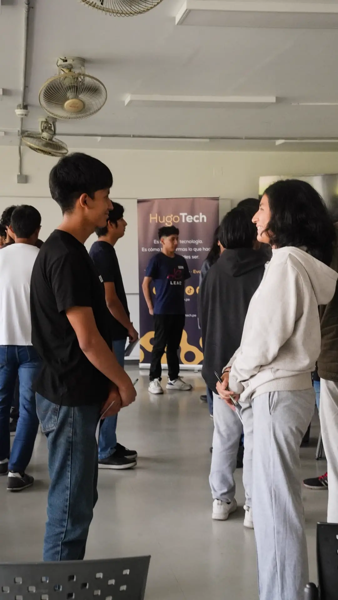 Dos estudiantes conversando cara a cara y riendo