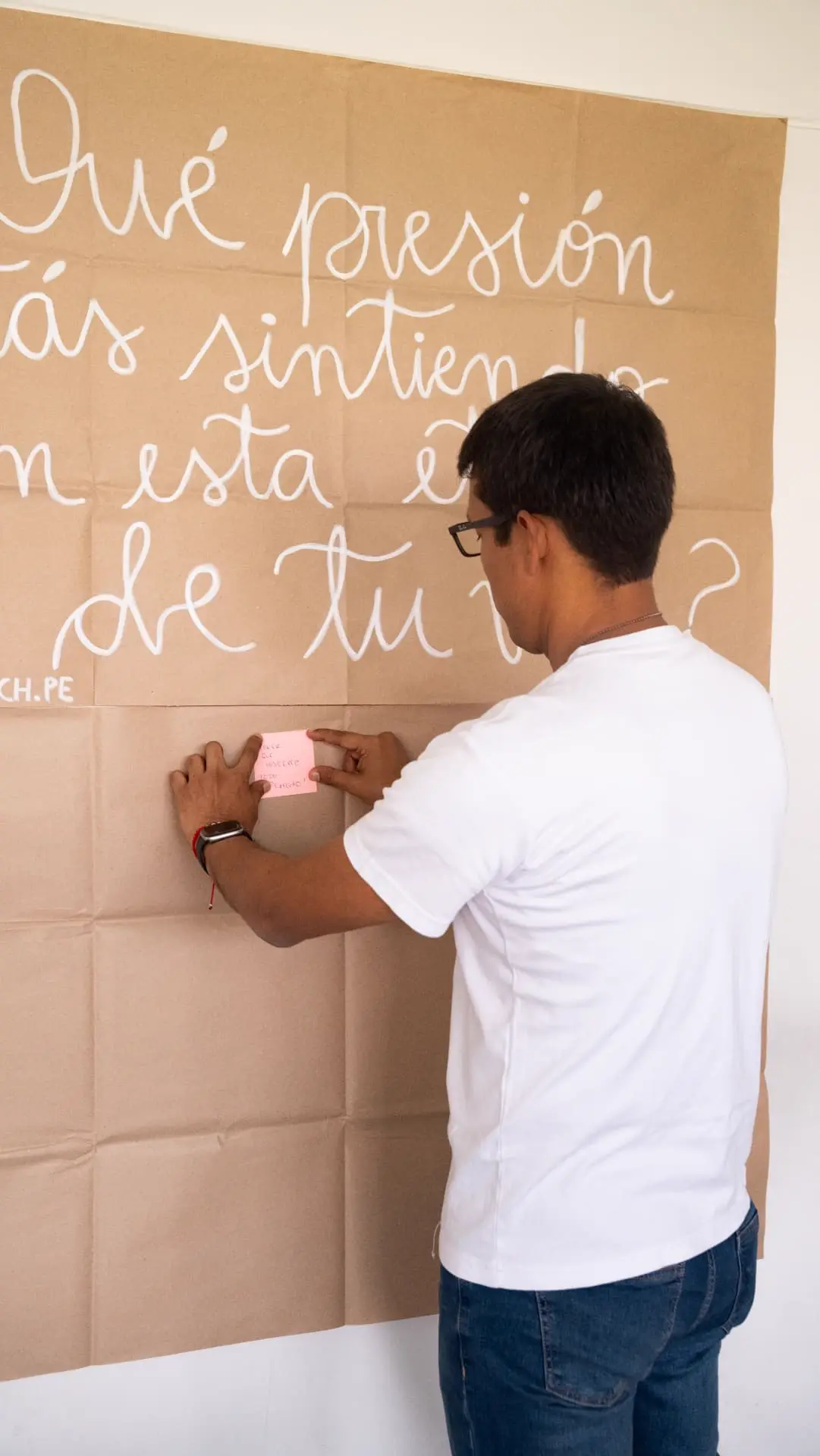 Hugo pegando un post-it en un papelógrafo con la pregunta sobre presión