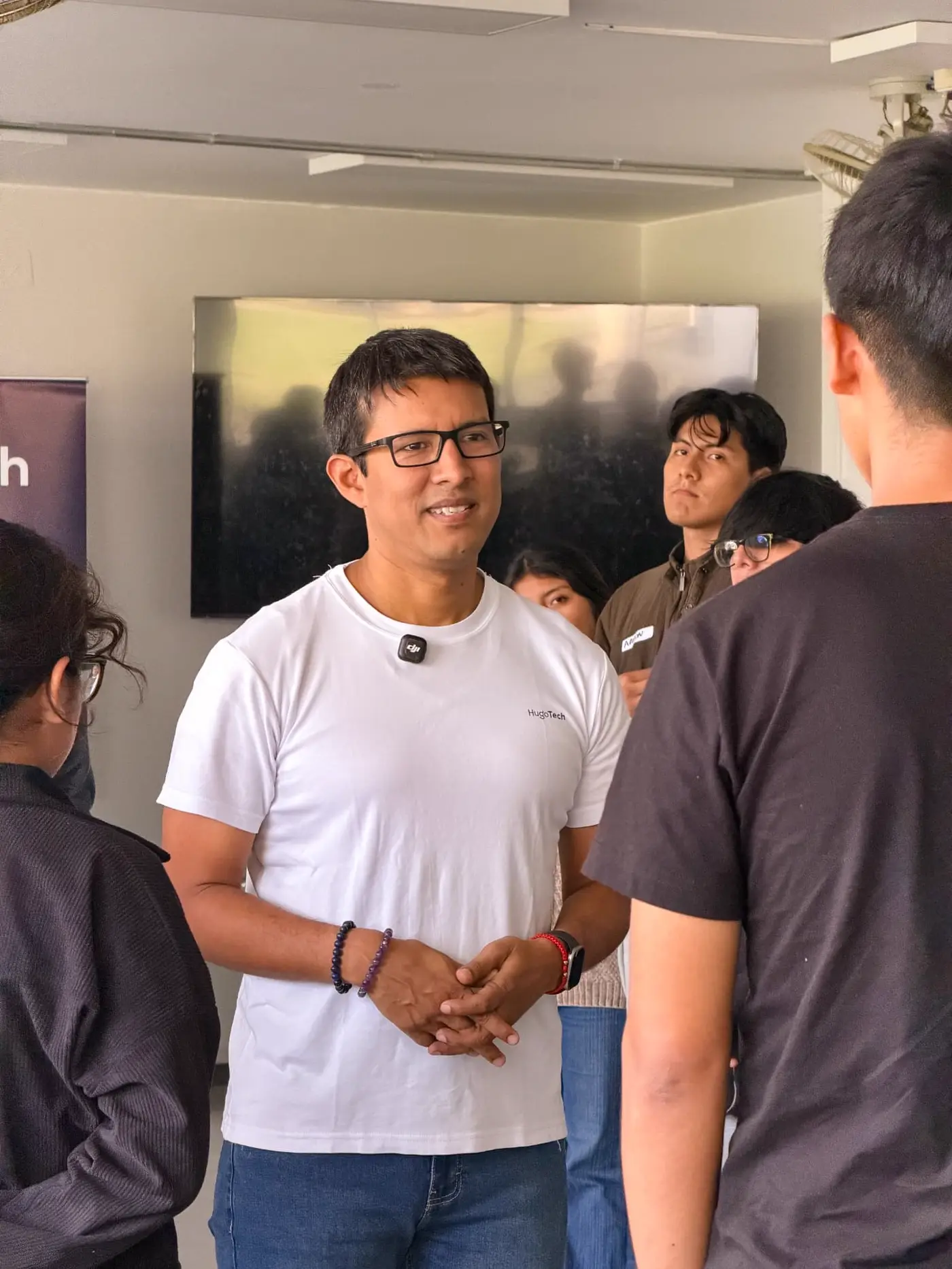 Hugo Casanova conversando de pie con estudiantes al inicio del taller