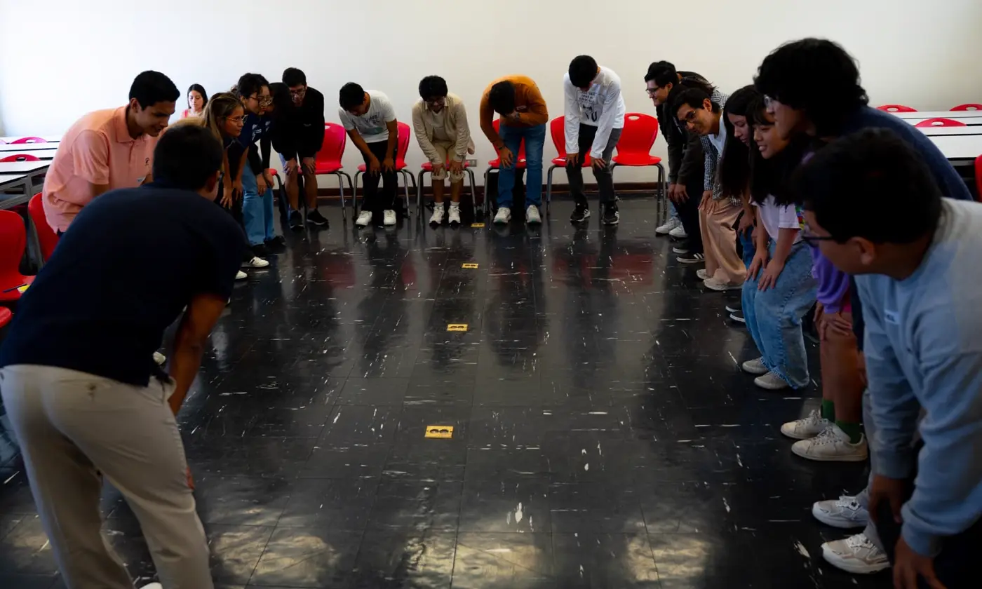 Estudiantes inclinados en dos filas enfrentadas durante un ejercicio