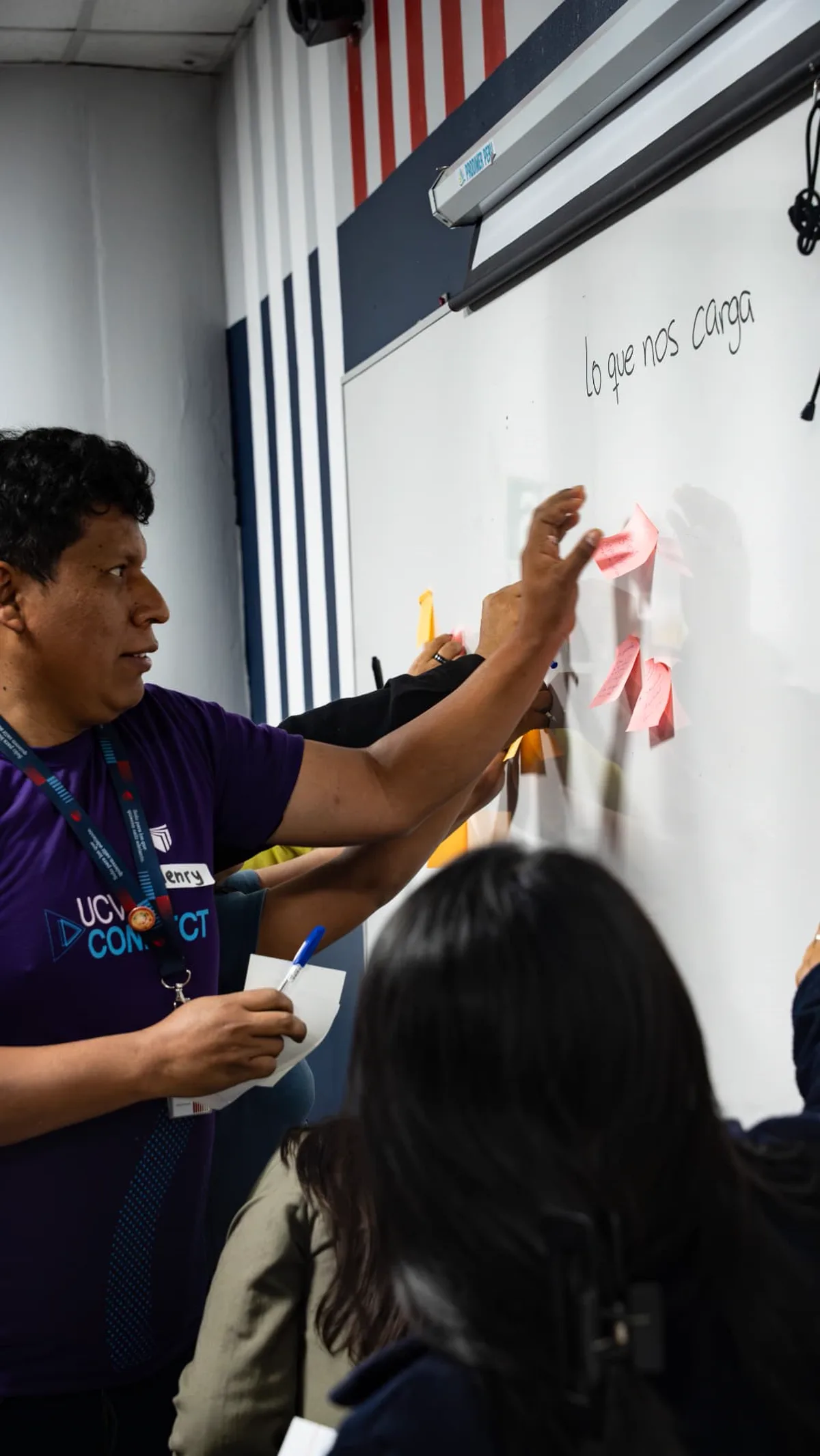 Participante UCV colocando post-its en el mural 'lo que nos carga'
