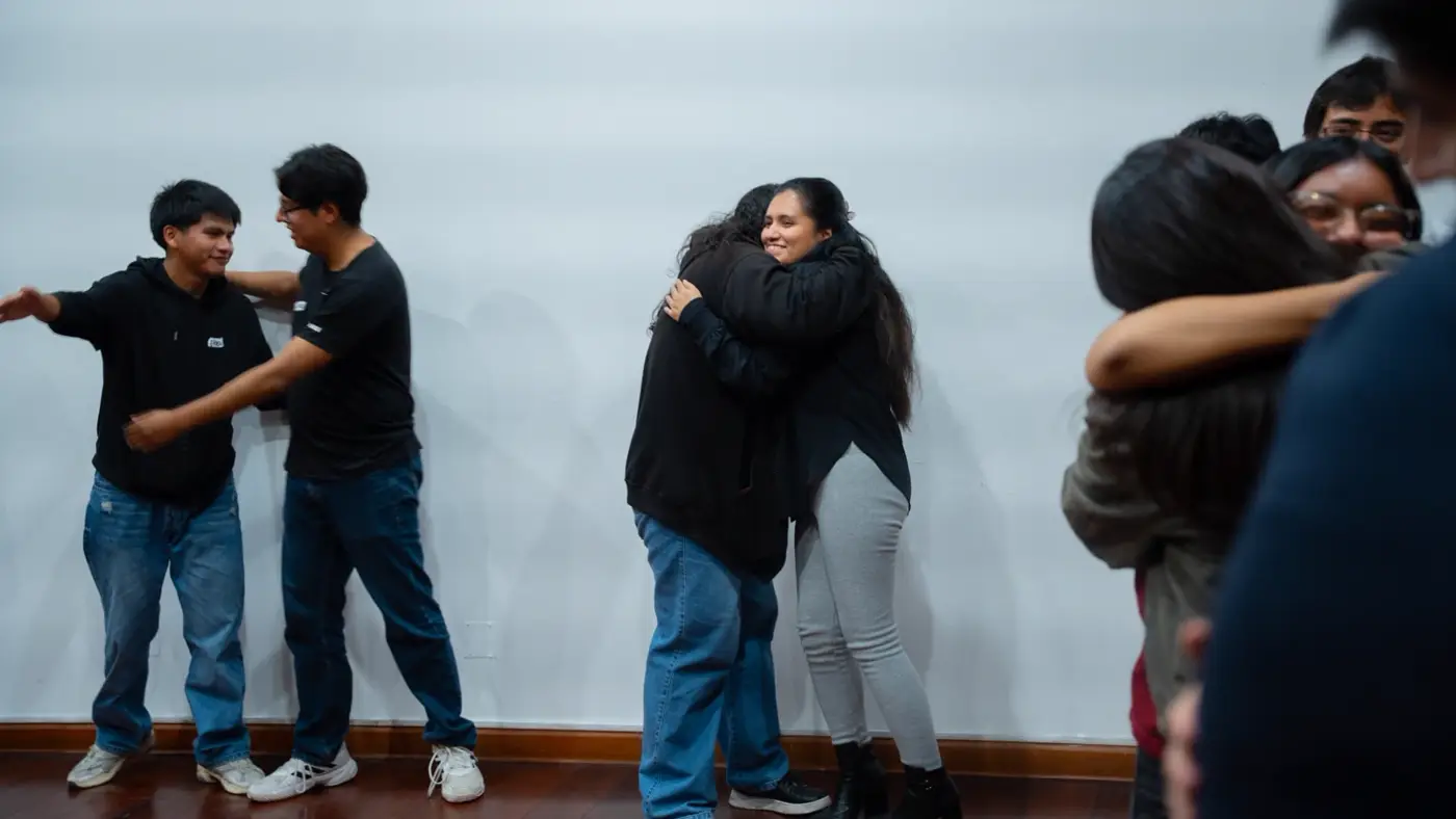 Estudiantes abrazándose al cierre del taller