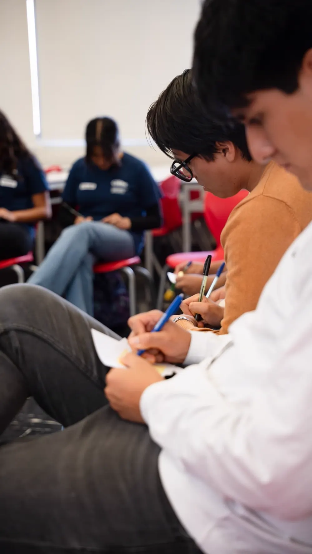 Estudiantes escribiendo sus reflexiones en papel