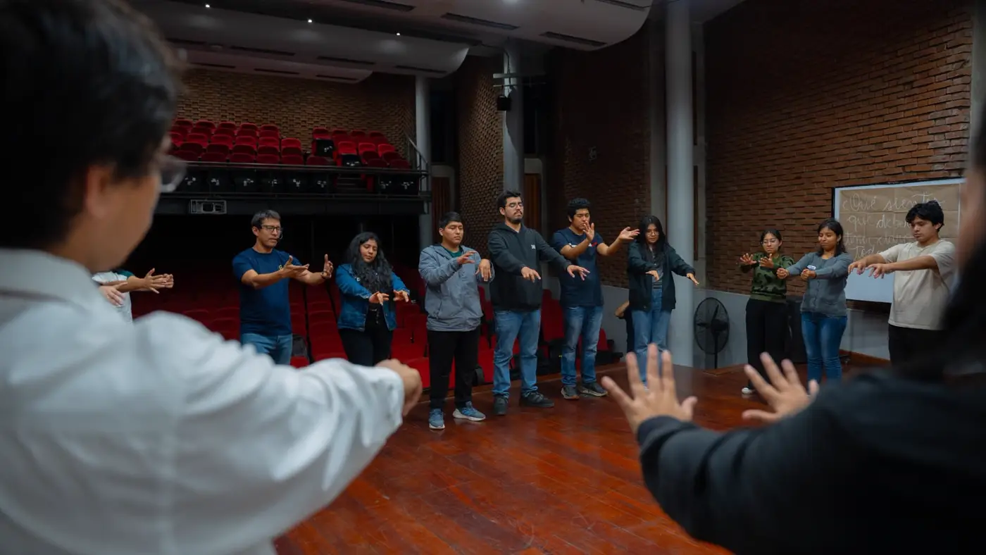 Grupo en fila practicando un ejercicio corporal en el auditorio