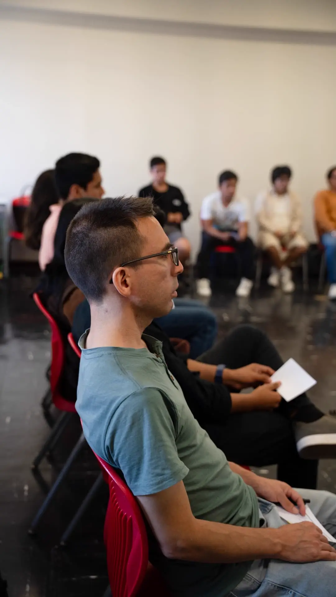 Participante escuchando atento sentado en círculo durante el taller