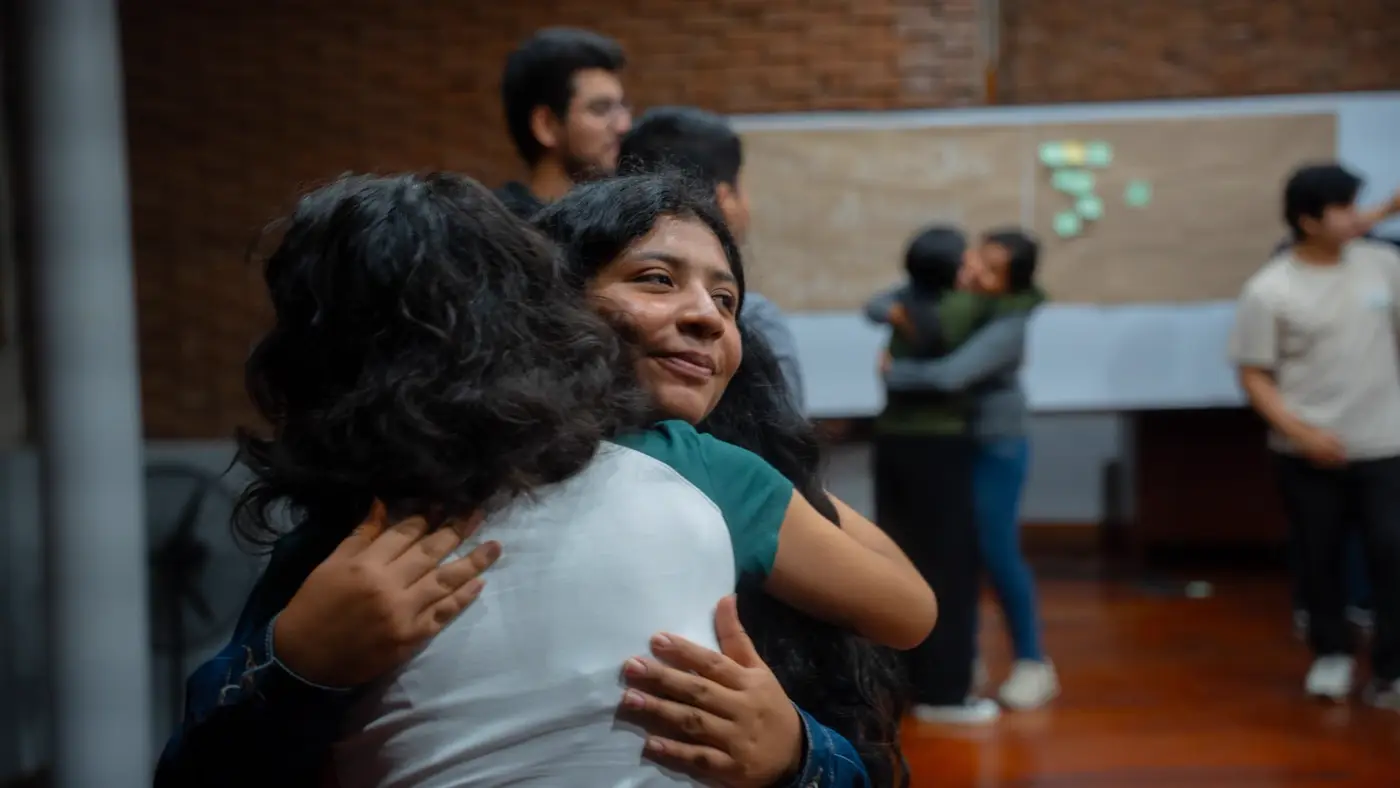 Dos estudiantes abrazadas sonriendo durante el cierre